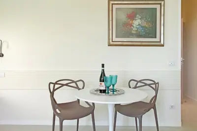 a white table with two chairs and a bottle of wine at Domus Augustea - San Giovanni Sunset Suites in Rome