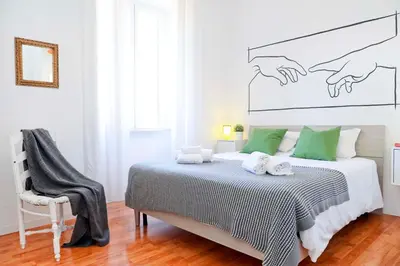 a bedroom with a bed with green pillows and a chair at Bella Nonna in Rome