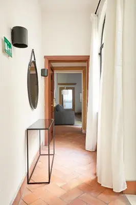 a living room with a glass table and a mirror at Montevecchio Boutique Apartments in Rome