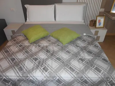 a bed with two green pillows on top of it at Via Cipro in Rome