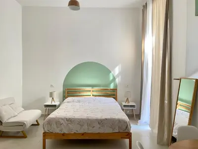 a white bedroom with a bed and a chair at Bed & Breakfast RCH Roman Central House in Rome