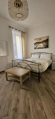 a bedroom with a bed and a table and a chandelier at La casa di Tilde Roma Angelino in Rome