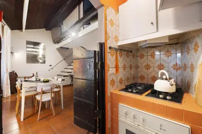 a small kitchen with a small island with stools at Trastevere Lovely Apartment in Rome