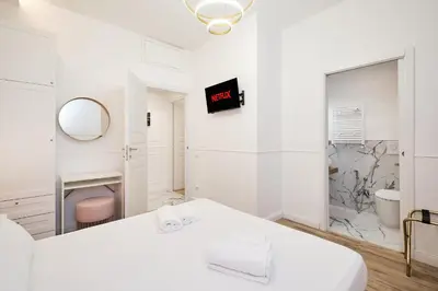 a white bedroom with a bed and a mirror at 5 minutes from the Vatican - Elegant flat - Wi-Fi in Rome