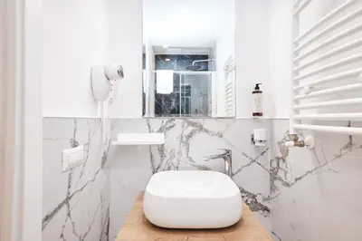 a white bathroom with a toilet and a phone at 5 minutes from the Vatican - Elegant flat - Wi-Fi in Rome
