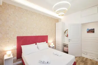 a bedroom with a white bed with a red headboard at 5 minutes from the Vatican - Elegant flat - Wi-Fi in Rome