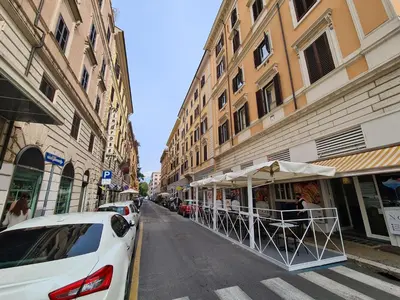 a white car parked on a street next to buildings at BnB Rooms And Comfort in Rome
