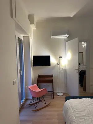 a bedroom with a pink chair and a desk at Trionfale Home in Rome