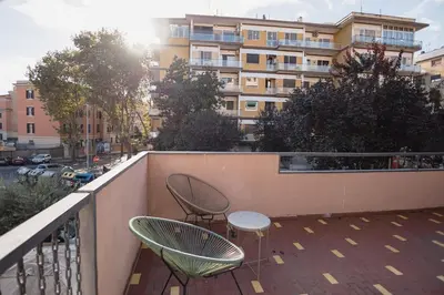 a balcony with two chairs and a table and a building at Trionfale Home in Rome