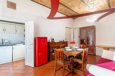 a kitchen with a table and a red refrigerator at Maison Colosseo in Rome