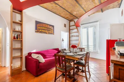 a living room with a table and a red couch at Maison Colosseo in Rome