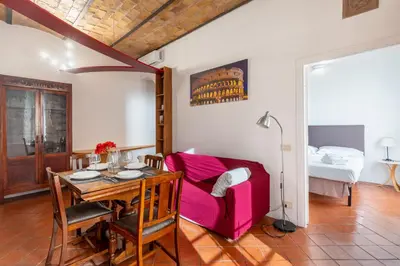 a dining room with a table and a bedroom at Maison Colosseo in Rome
