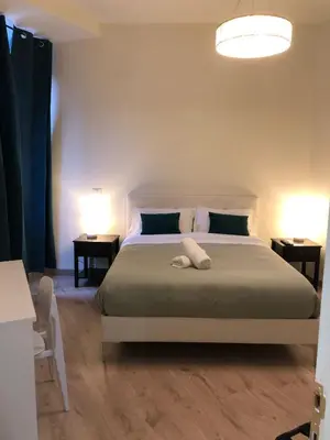 a bedroom with a bed with two tables and two lamps at B&B Rome Vatican Residence in Rome