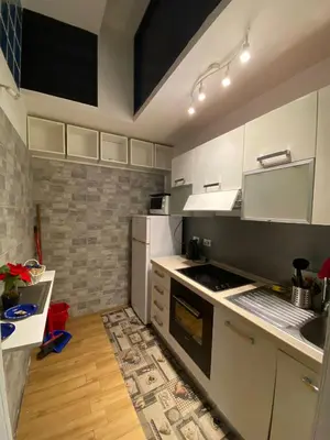 a kitchen with white cabinets and a stove top oven at LaCasitaDeAU - Trastevere-Monteverde-Vaticano in Rome