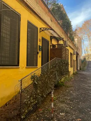 a yellow building with a balcony on a street at LaCasitaDeAU - Trastevere-Monteverde-Vaticano in Rome
