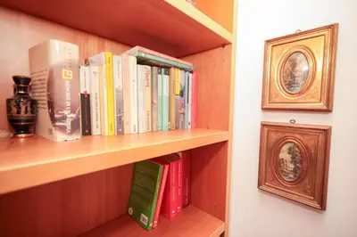 a book shelf filled with books next to a wall at La Casa di Piero in Rome