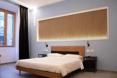 a bedroom with a large bed and a large window at Lilium Suites in Rome