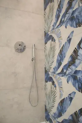 a shower in a bathroom with blue and white wallpaper at Lilium Suites in Rome