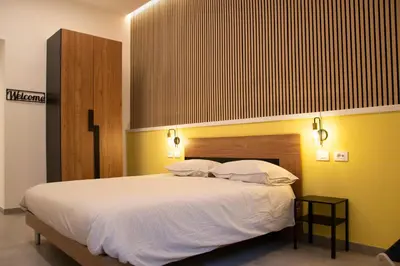 a bedroom with a large white bed with yellow walls at Lilium Suites in Rome