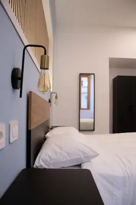 a bedroom with a bed with a lamp and a mirror at Lilium Suites in Rome