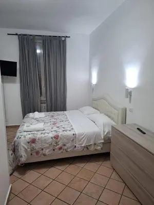 a bedroom with a bed with a floral comforter at APARTAMENTO NAPOLEONe 38 in Rome