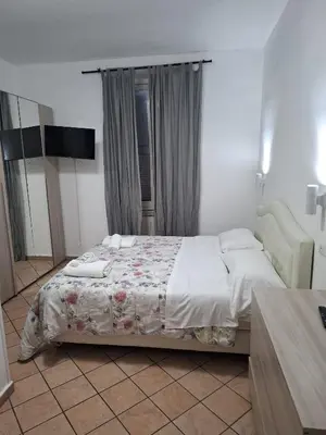 a bedroom with a bed and a chair at APARTAMENTO NAPOLEONe 38 in Rome