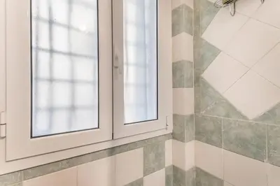 a bathroom with two windows and a tiled wall at Villa Up in Rome