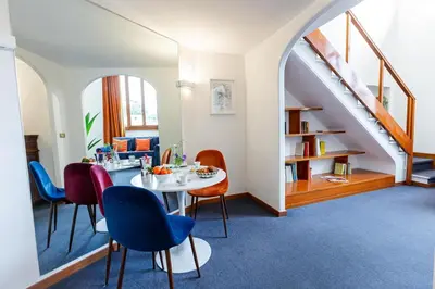 a dining room with a table and chairs and a staircase at Spanish Steps Luxury Apartment in Rome