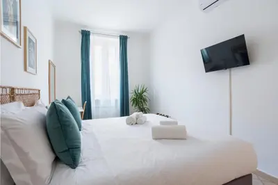 a bedroom with a white bed with a tv on it at Terrazza San Lorenzo - Luxury Apartment - Roma Centro in Rome