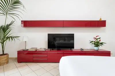 a red entertainment center with a flat screen tv at Terrazza San Lorenzo - Luxury Apartment - Roma Centro in Rome