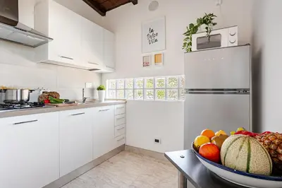 a kitchen with white cabinets and a bowl of fruit at Casa Doria - ROMA in Rome