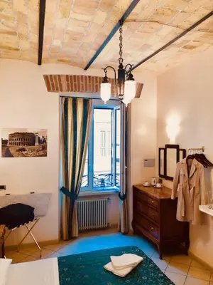 a bedroom with a bed and a dresser and a window at Optimus B&B in Rome