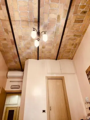 a room with a refrigerator and a ceiling with lights at Optimus B&B in Rome
