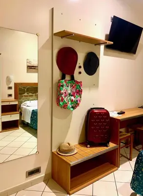 a room with a mirror and a suitcase on a shelf at Optimus B&B in Rome