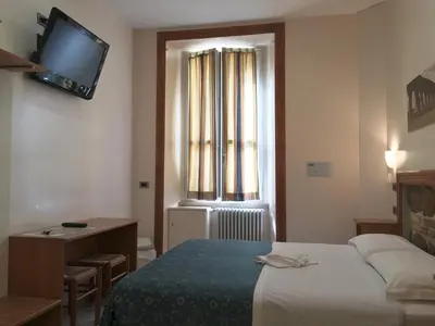 a hotel room with a bed and a television on the wall at Optimus B&B in Rome