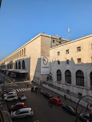a large building with cars parked in a parking lot at Roomz Romestay in Rome