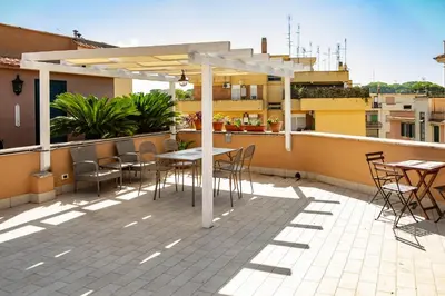 a patio with tables and chairs on a roof at St Peter Clivo 1 by BuddyRent in Rome