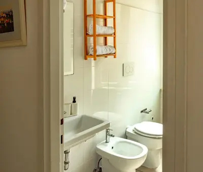 a white bathroom with a toilet and a sink at St Peter Clivo 1 by BuddyRent in Rome