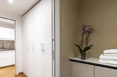 a bathroom with a white cabinet with a vase of flowers at Italian Experience-Suite Trastevere in Rome