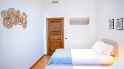 a white bedroom with a bed and a door at Marble House 7 in Rome