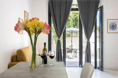 a table with a vase of flowers and two glasses of wine at Urban Oasis near Termini, free Parking&Patio, int3 in Rome