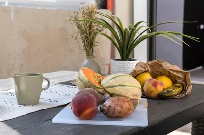a table with a plate of fruit and a cup at Urban Oasis near Termini, free Parking&Patio, int3 in Rome