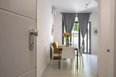 a dining room with a table with a vase of flowers on it at Urban Oasis near Termini, free Parking&Patio, int3 in Rome