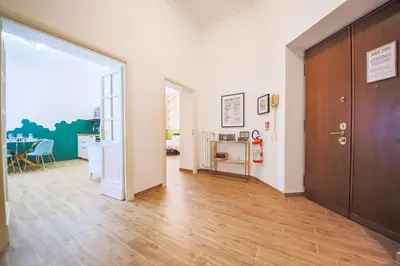 a hallway with a wooden door and a table at Casa Fen Palazzo Storico - Re di Roma metro A - 2camere2bagni in Rome