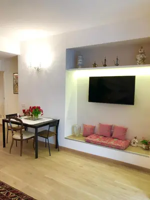 a dining room with a table and a tv on a wall at Casa di Corto in Rome