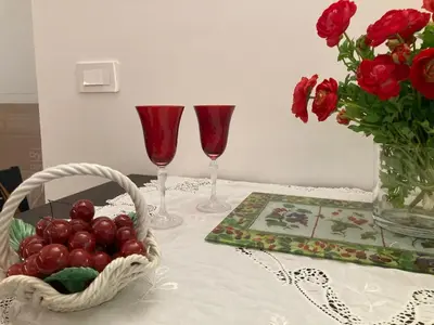 a table with two wine glasses and a basket of fruit at Casa di Corto in Rome