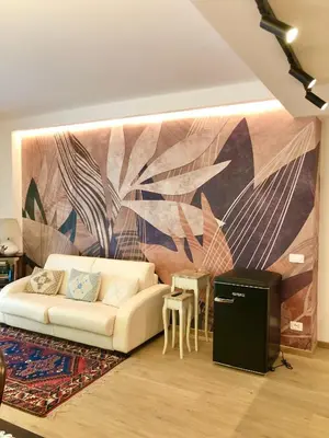 a living room with a white couch in front of a mural at Casa di Corto in Rome