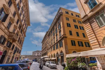 a city street with buildings and cars parked on the street at Vatican Eagle Rooms in Rome