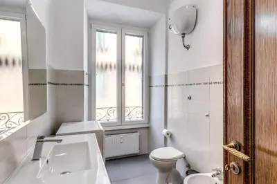 a white bathroom with a toilet and a sink at Vatican Eagle Rooms in Rome