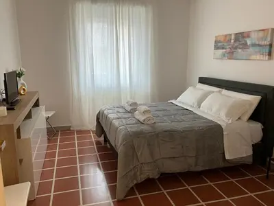 a bedroom with a bed with a tiled floor at FAIROME Apartment Albricci in Rome